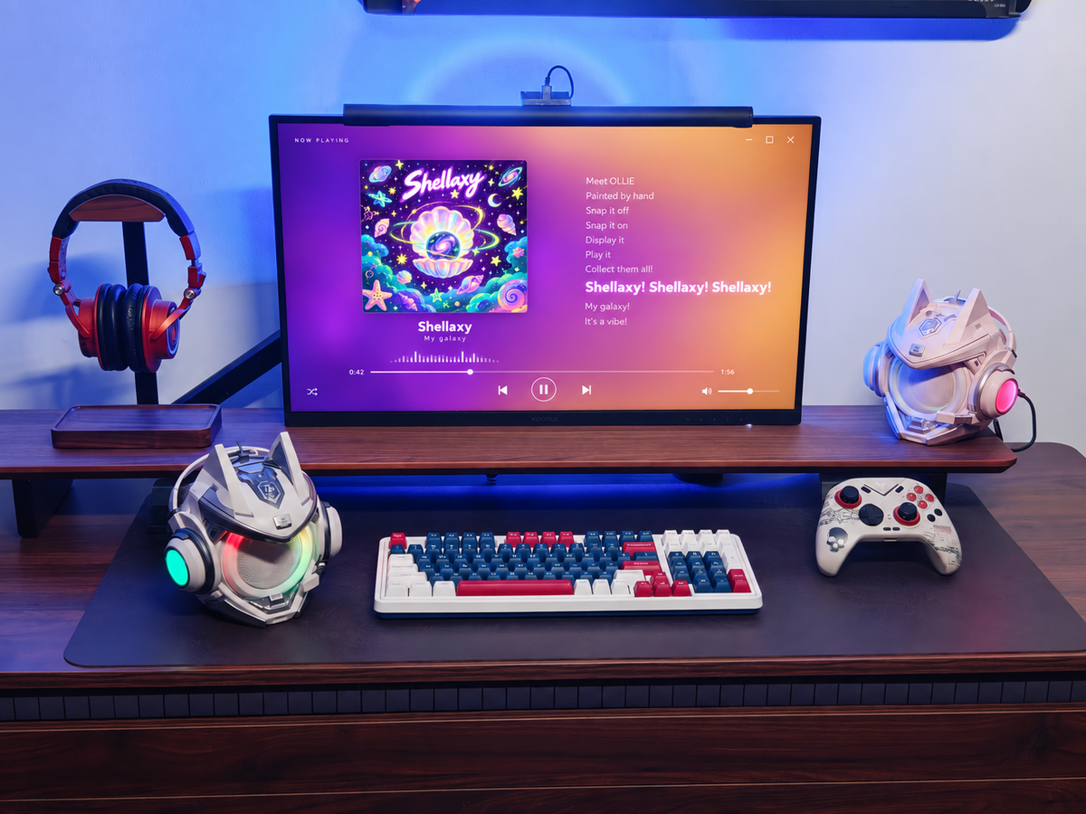 Two OLLIE speakers beside a monitor playing Shellaxy original music